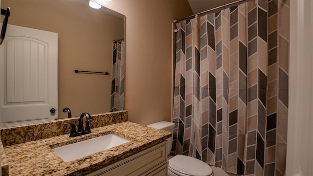 bathroom with curtained shower, vanity, and toilet