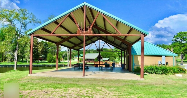 view of community with a patio area, a water view, a yard, and a gazebo