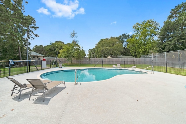 view of swimming pool featuring a fenced in pool, a patio area, fence, and a lawn