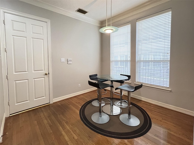 dining space featuring ornamental molding, dark wood-type flooring, and a wealth of natural light