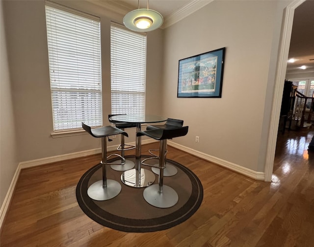 dining area featuring dark hardwood / wood-style floors and crown molding