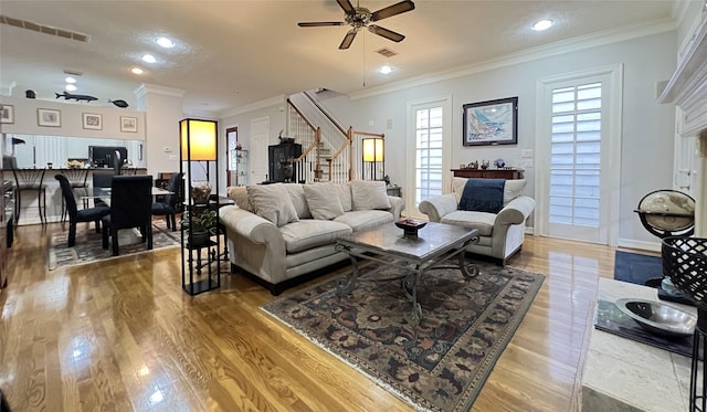 living room featuring ceiling fan, plenty of natural light, and ornamental molding