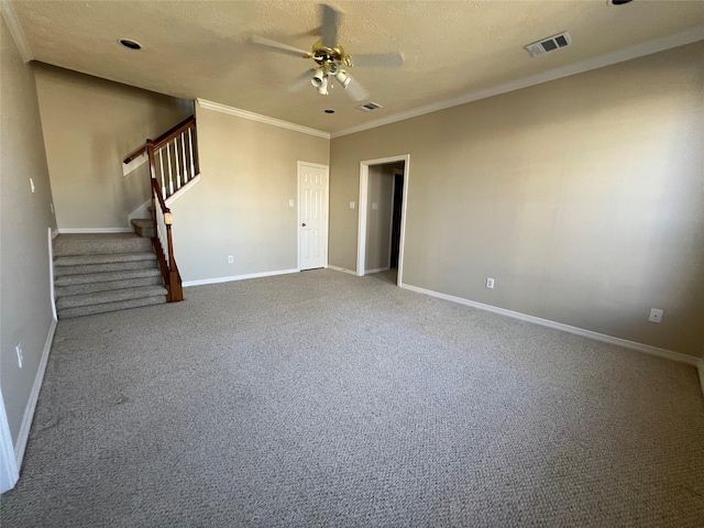 carpeted spare room with ceiling fan, ornamental molding, and a textured ceiling