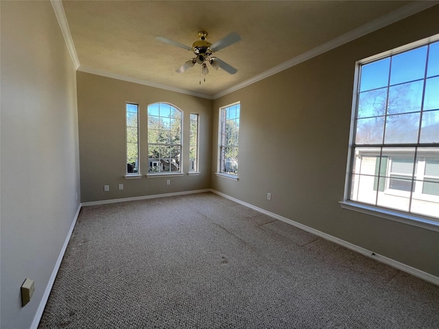 carpeted spare room with a wealth of natural light, ornamental molding, and ceiling fan