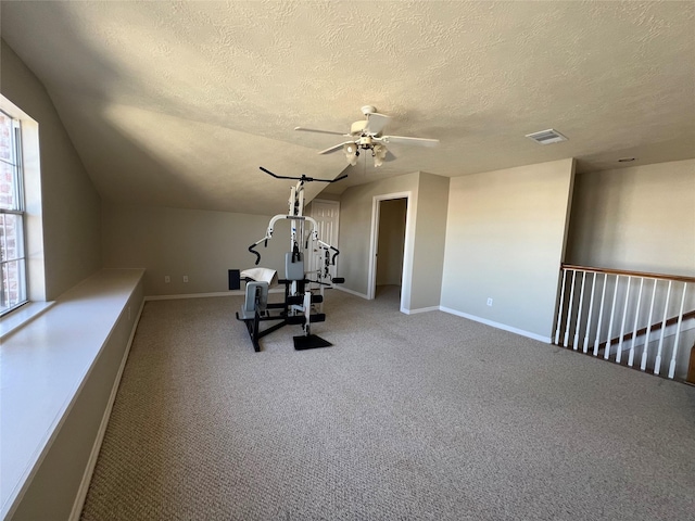 workout area with ceiling fan, carpet floors, and a textured ceiling