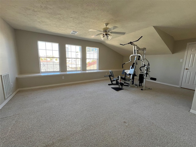 workout area with a textured ceiling, ceiling fan, light carpet, and vaulted ceiling