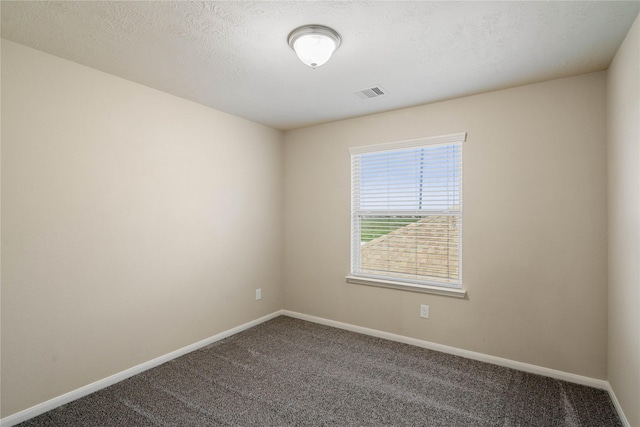 empty room with carpet floors and a textured ceiling