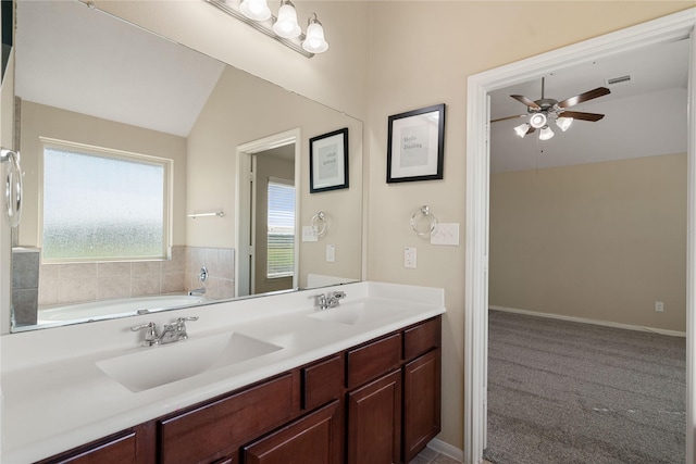 bathroom with ceiling fan, a washtub, vanity, and lofted ceiling