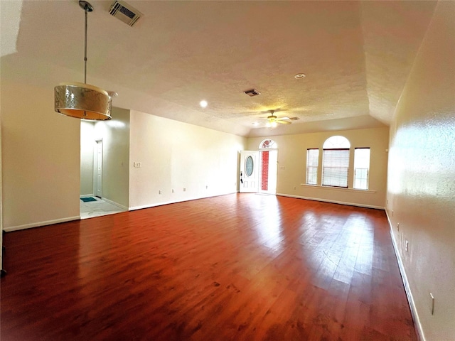 empty room featuring a textured ceiling, hardwood / wood-style flooring, ceiling fan, and lofted ceiling