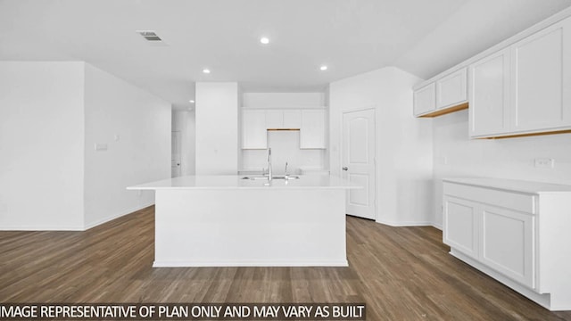 kitchen featuring white cabinets, dark hardwood / wood-style floors, and a kitchen island with sink