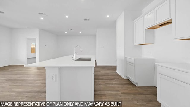 kitchen with hardwood / wood-style floors, an island with sink, white cabinetry, and sink