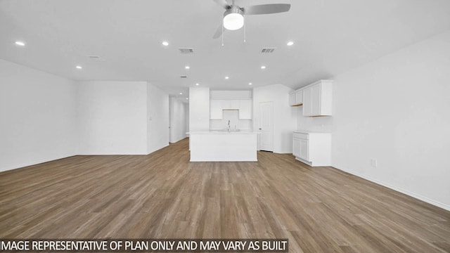 unfurnished living room with light wood-type flooring, ceiling fan, and sink