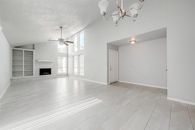 unfurnished living room featuring high vaulted ceiling, ceiling fan with notable chandelier, a brick fireplace, built in shelves, and a textured ceiling