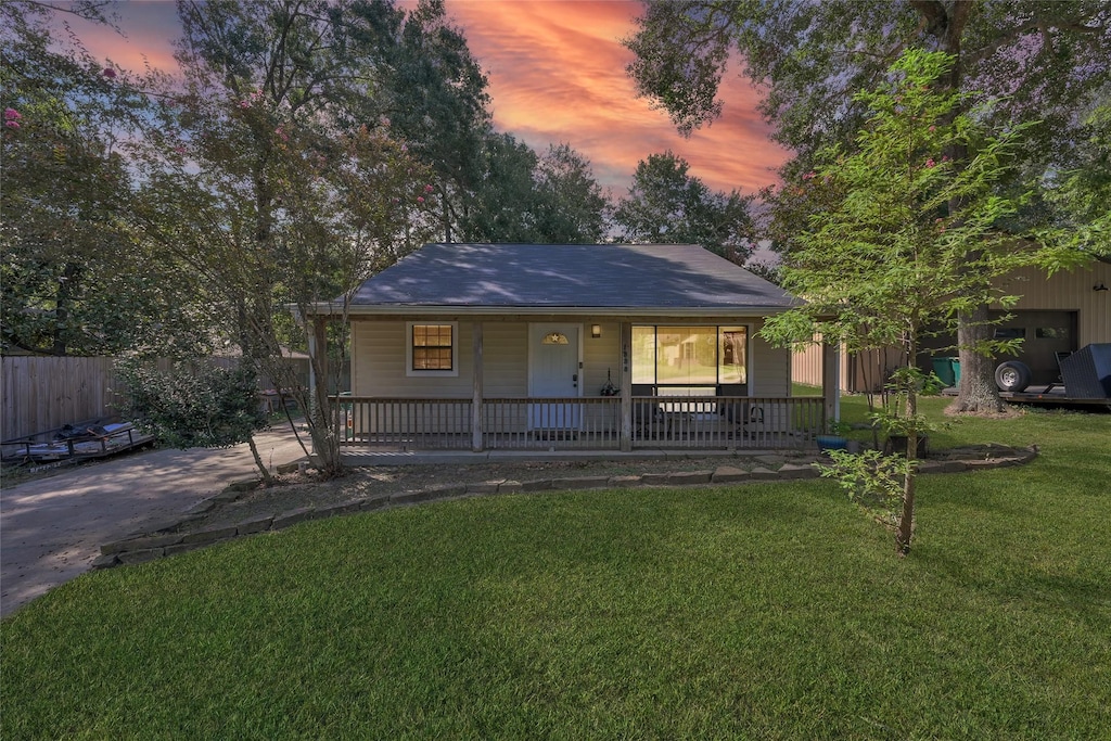 view of front facade featuring covered porch and a yard