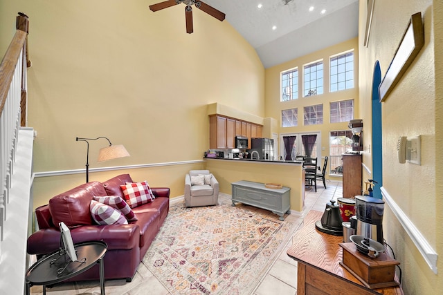 living room featuring ceiling fan, high vaulted ceiling, and light tile patterned flooring