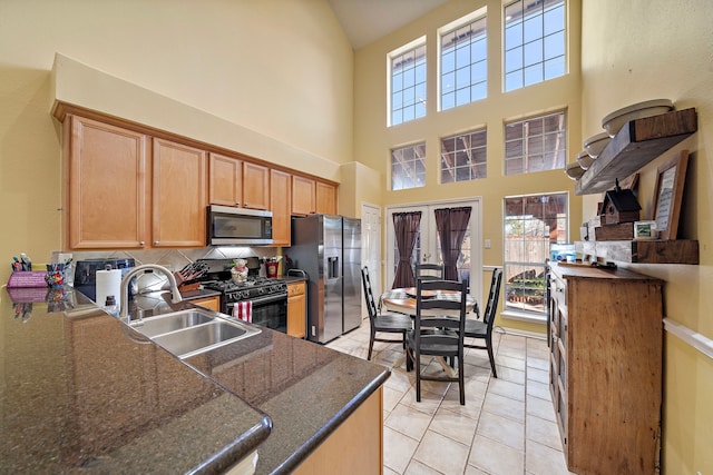 kitchen featuring sink, french doors, stainless steel appliances, tasteful backsplash, and light tile patterned flooring