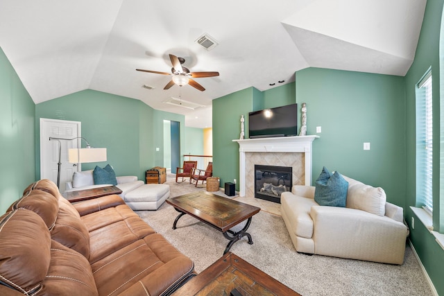 living room featuring a tile fireplace, vaulted ceiling, and ceiling fan