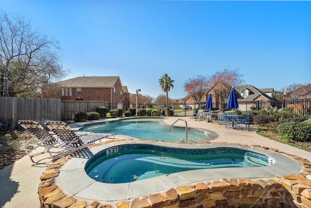 view of swimming pool with an in ground hot tub and a patio