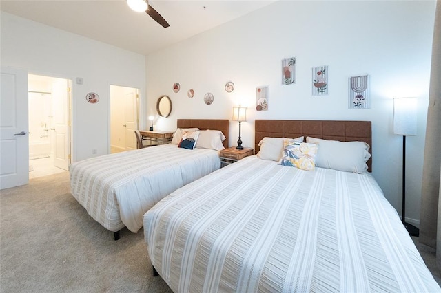 bedroom featuring connected bathroom, light colored carpet, and ceiling fan