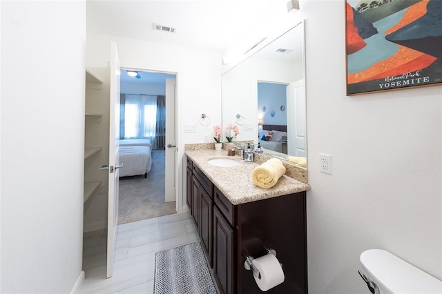 bathroom featuring tile patterned flooring, vanity, and toilet