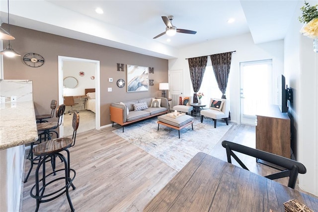 living room with ceiling fan and light hardwood / wood-style floors