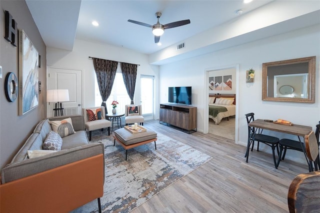 living room featuring light hardwood / wood-style flooring and ceiling fan