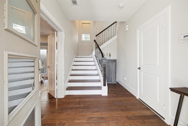 foyer entrance featuring a wealth of natural light and dark hardwood / wood-style floors