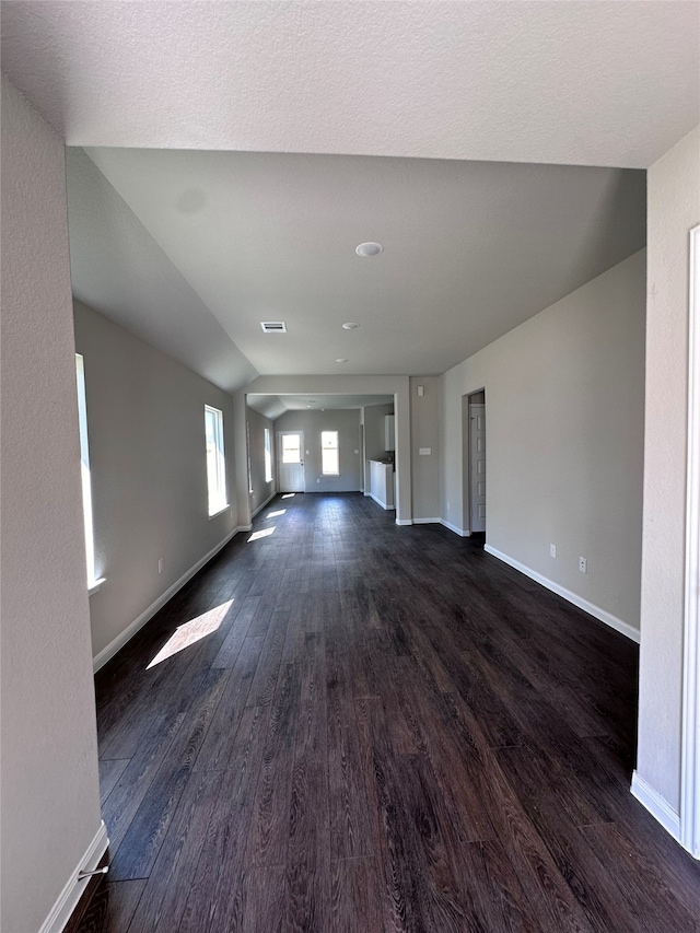 unfurnished living room featuring dark hardwood / wood-style flooring and lofted ceiling