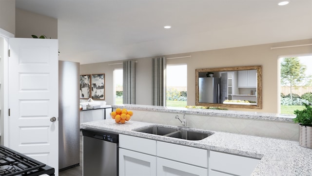 kitchen featuring light stone countertops, stainless steel appliances, white cabinetry, and sink