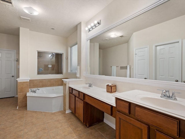 bathroom with tile patterned floors, separate shower and tub, vanity, and a textured ceiling