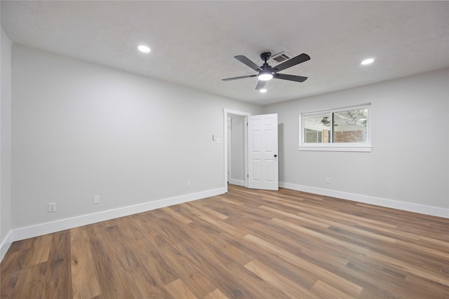 empty room with hardwood / wood-style floors and ceiling fan