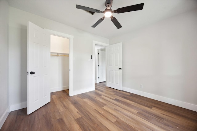 unfurnished bedroom with ceiling fan, a closet, and hardwood / wood-style floors