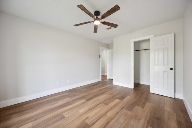 unfurnished bedroom featuring hardwood / wood-style flooring, ceiling fan, and a closet