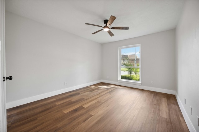 spare room with dark hardwood / wood-style flooring and ceiling fan