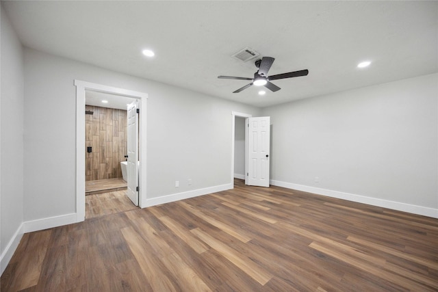 unfurnished bedroom featuring ensuite bathroom, dark hardwood / wood-style flooring, and ceiling fan