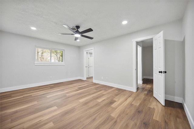 empty room with a textured ceiling, light hardwood / wood-style flooring, and ceiling fan