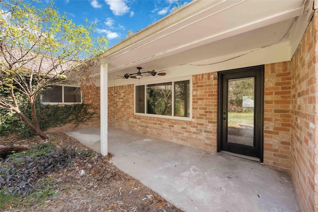 doorway to property with ceiling fan and a patio area