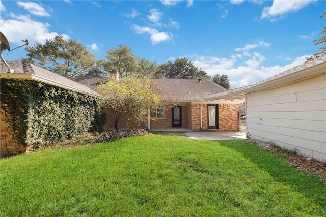 back of property featuring a patio area and a yard