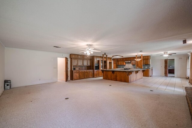 unfurnished living room featuring ceiling fan, light colored carpet, and a textured ceiling