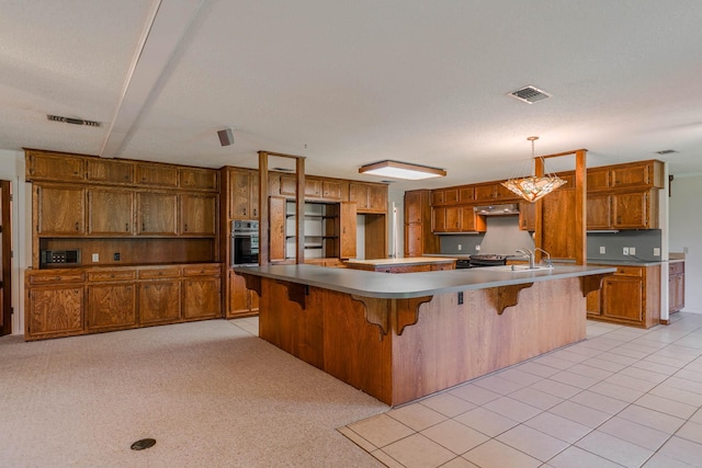 kitchen featuring a kitchen breakfast bar, stainless steel oven, exhaust hood, decorative light fixtures, and a large island