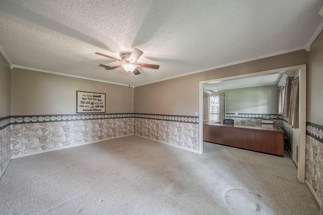 unfurnished room featuring ceiling fan, light colored carpet, a textured ceiling, and ornamental molding