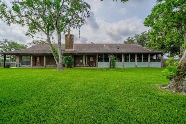 back of house with a sunroom and a yard