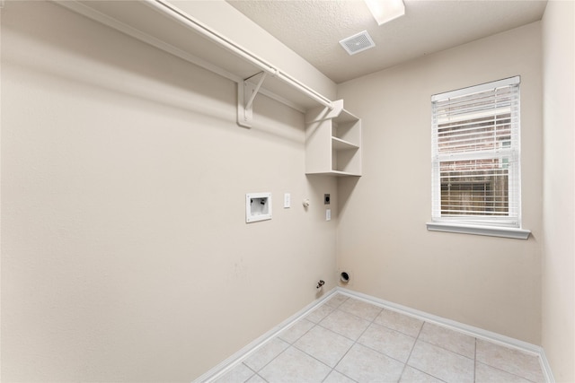 clothes washing area with electric dryer hookup, gas dryer hookup, hookup for a washing machine, and a textured ceiling