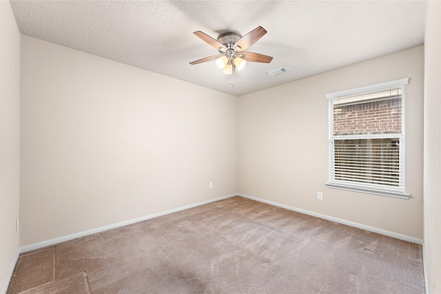 empty room featuring a textured ceiling, carpet floors, and ceiling fan