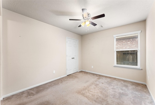 carpeted empty room with a textured ceiling and ceiling fan