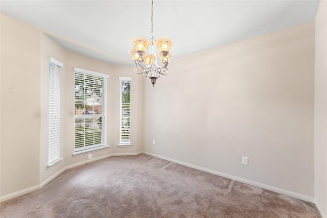 carpeted empty room featuring a notable chandelier