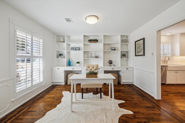 office area with built in shelves, dark hardwood / wood-style floors, a healthy amount of sunlight, and sink