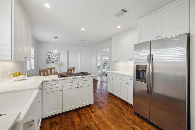 kitchen featuring decorative backsplash, dark hardwood / wood-style flooring, stainless steel appliances, pendant lighting, and white cabinetry