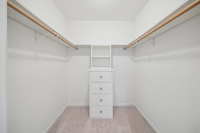 walk in closet featuring light carpet