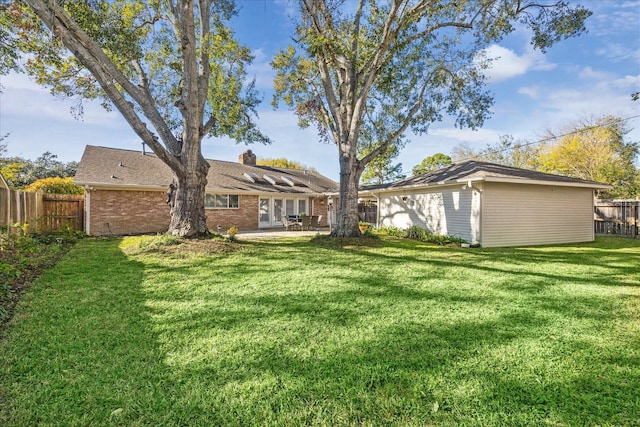 back of house with a yard and a patio area